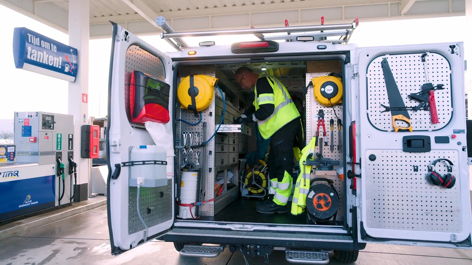 Onderhoudsmonteur aan het werk in een servicebus vol gereedschap bij een tankstation