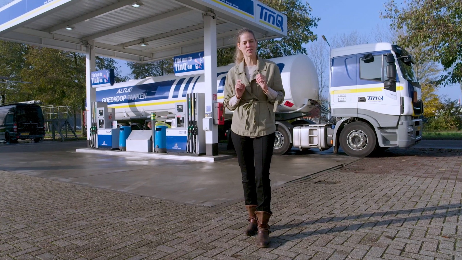 Tankwagenchauffeur loopt over het terrein van een TinQ-tankstation, met de tankwagen erachter