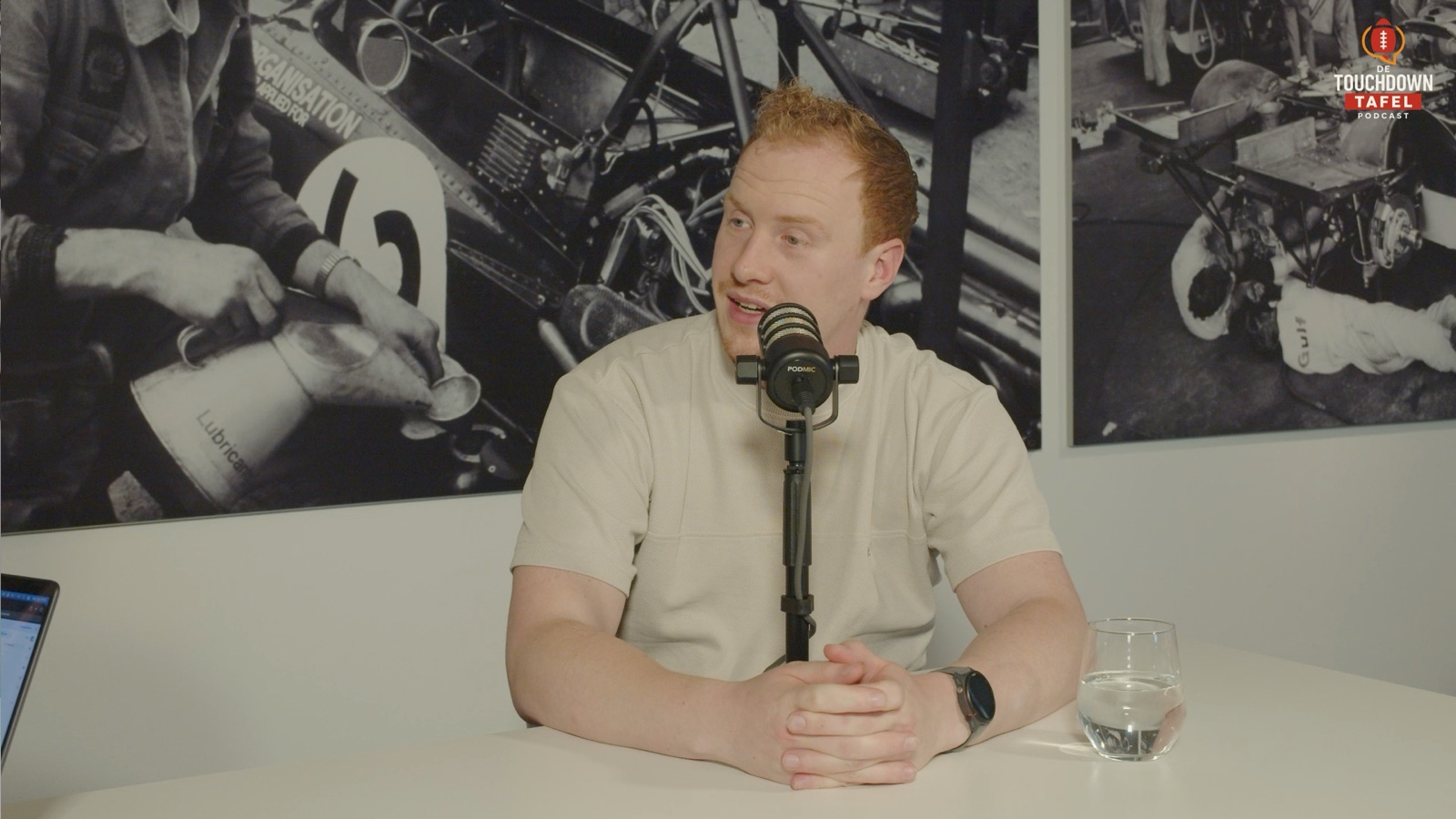 Presentator aan tafel achter de microfoon bij De Touchdown Tafel