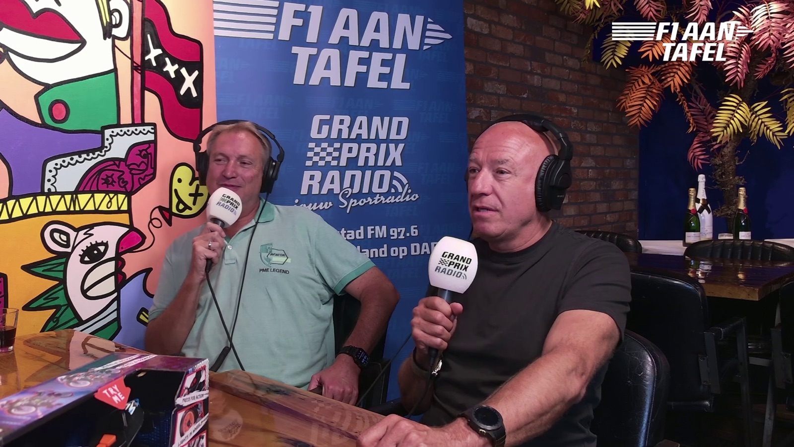 Gesprek aan tafel bij F1 aan Tafel, met de banner van Grand Prix Radio erachter